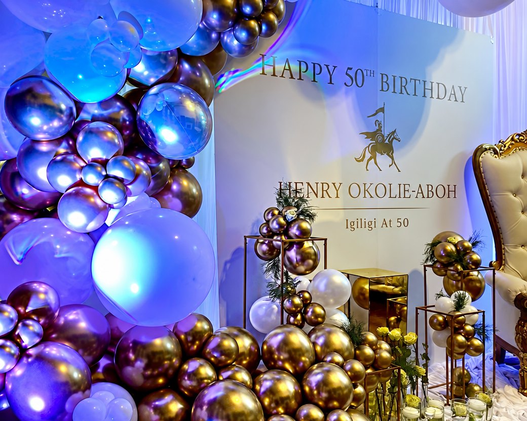 Fiftieth birthday: gold balloon towers and a lettered backdrop