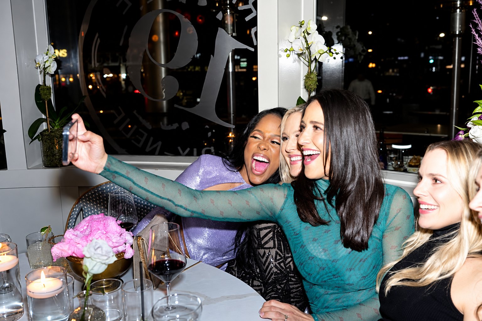 Dinner party: guests taking a selfie at a candlelit table