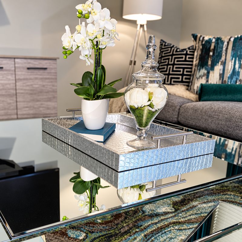 Living room detail: white orchids and a glass apothecary jar on a mirrored tray
