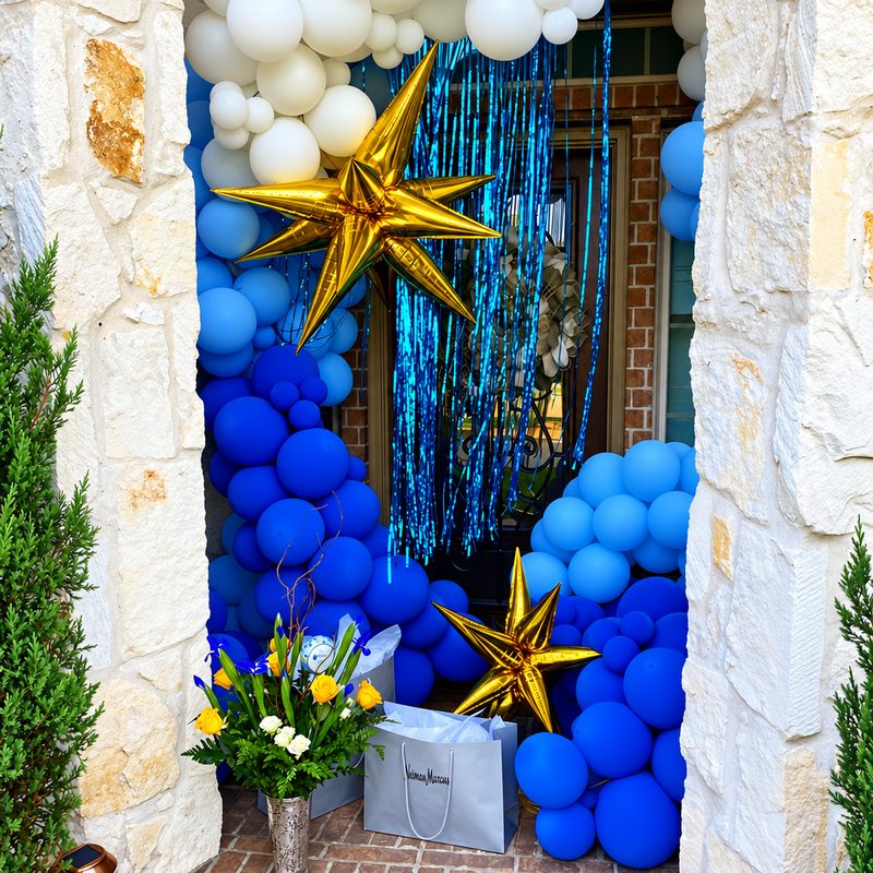 Blue and white balloon arch with gold stars framing a stone doorway